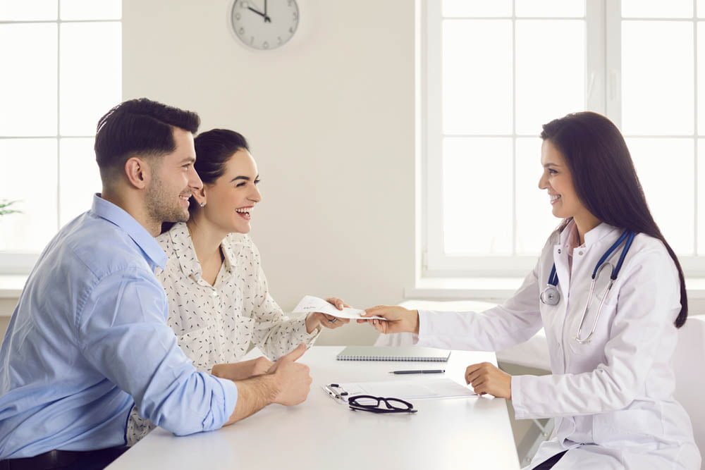 3 pessoas em uma mesa conversando sobre reversão de vasectomia