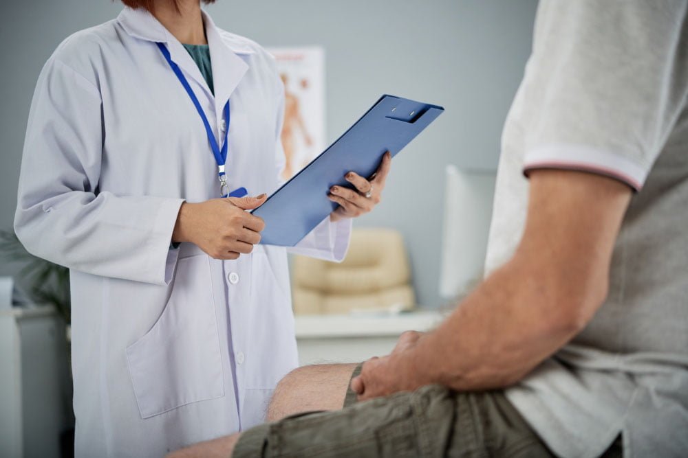 Médica orientando paciente sobre cuidados com a cirurgia de reversão de vasectomia